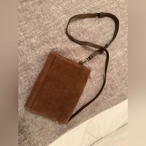 Brown suede crossbody purse with magnetic closure.